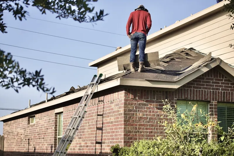 Professional roofer working on a residential roof in Janvier